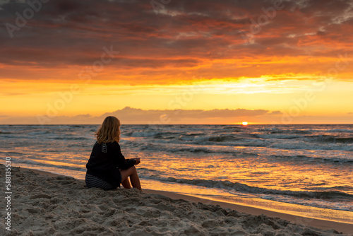 Dziewczyna oglądająca zachód słońca nad Bałtykiem  / A girl watching the sunset over the Baltic Sea