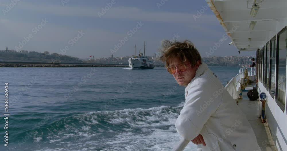 A young stylish hipster man rides a passenger ship across the sea. A ferry sails by, a scene in Turkey Istanbul. High quality 4k footage A young stylish hipster man rides a passenger ship across the sea. A ferry sails by, a scene in Turkey Istanbul. High quality 4k footage