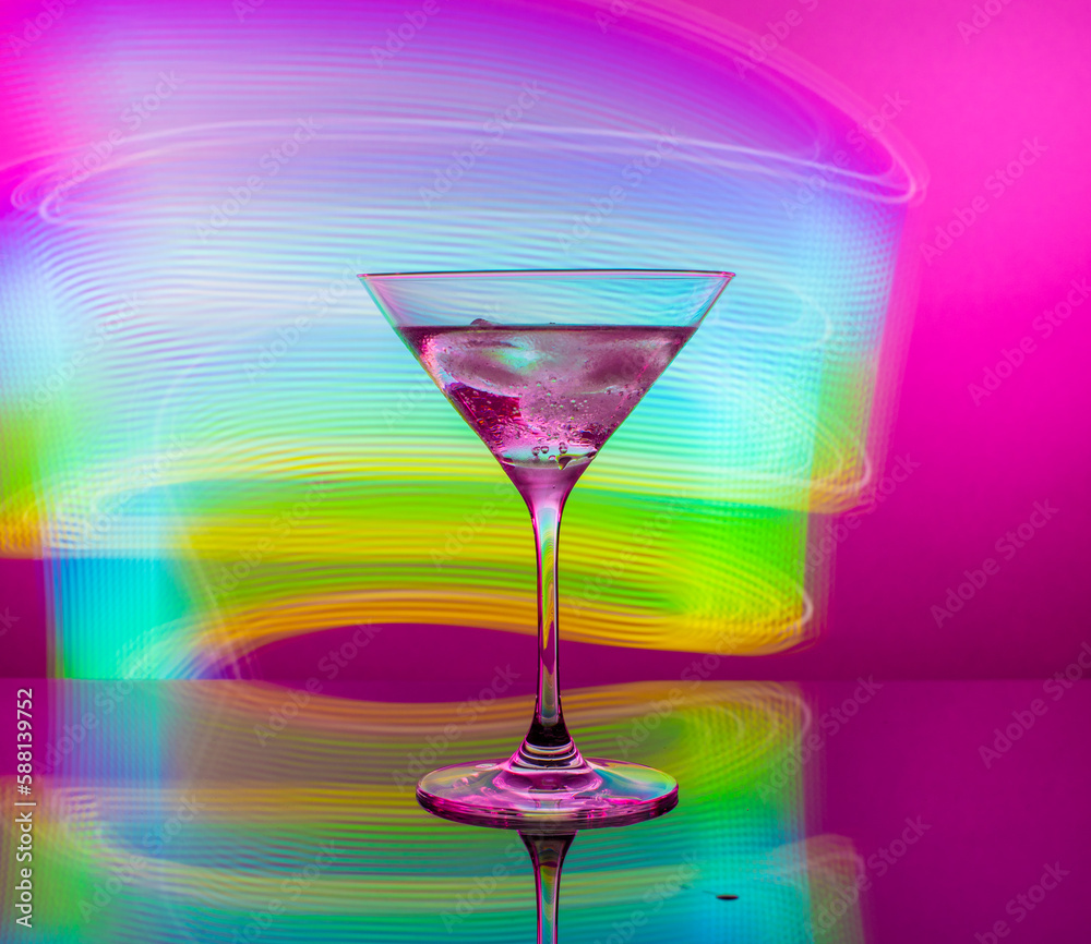 Alcoholic martini cocktail in a glass goblet on a background of blue neon lights Alcoholic martini cocktail in a glass goblet on a background of blue neon lights