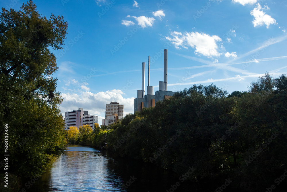 Hannover, Germany - October 16, 2022. Beautiful Ihme river with trees and in the background the heating plant with the three towers
