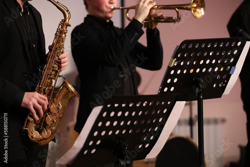 Band of brass instruments saxophone and trumpet playing on stage concert