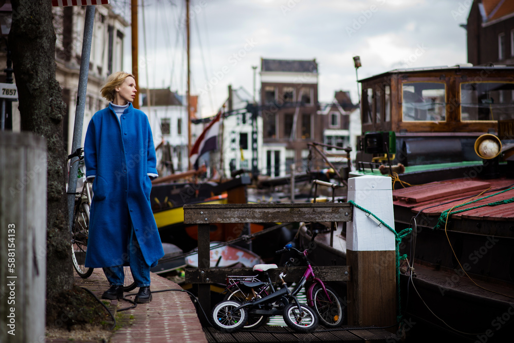 Woman tourist in the bay with ships in the Netherlands. Cityscape of Rotterdam. Travel and adventure.