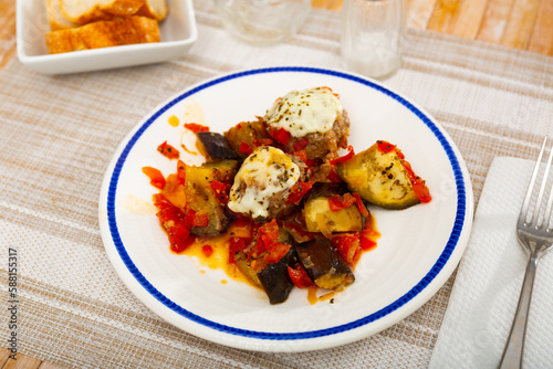 Fried meatballs with aubergine and melted cheese, served with stewed vegetables and bread