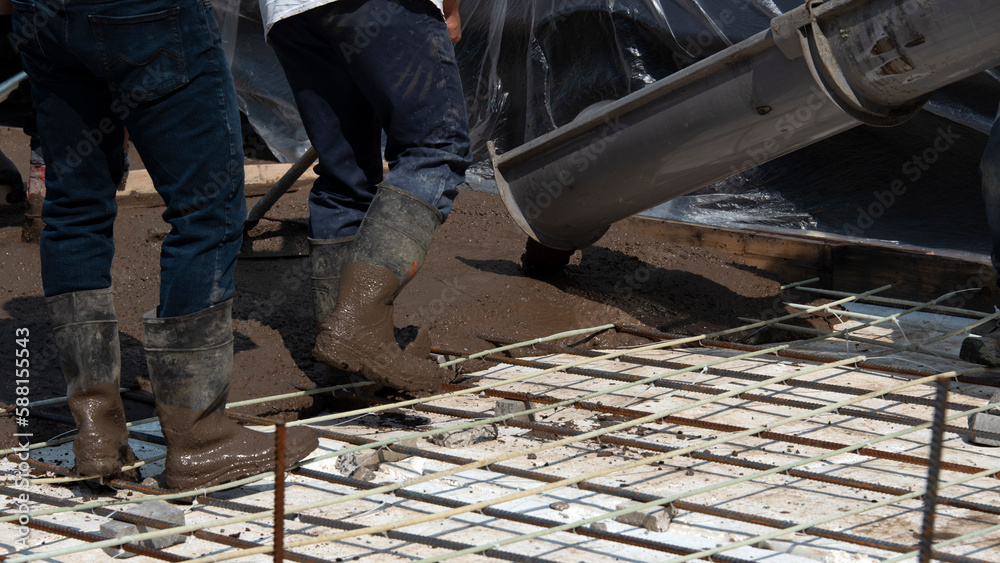 Workers pouring concrete for a stamped floor Workers pouring concrete for a stamped floor