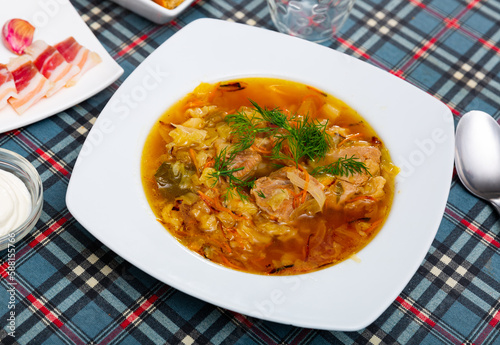 Thick Russian-style cabbage soup (Shchi) with pork cooked in mushroom broth served with sour cream..