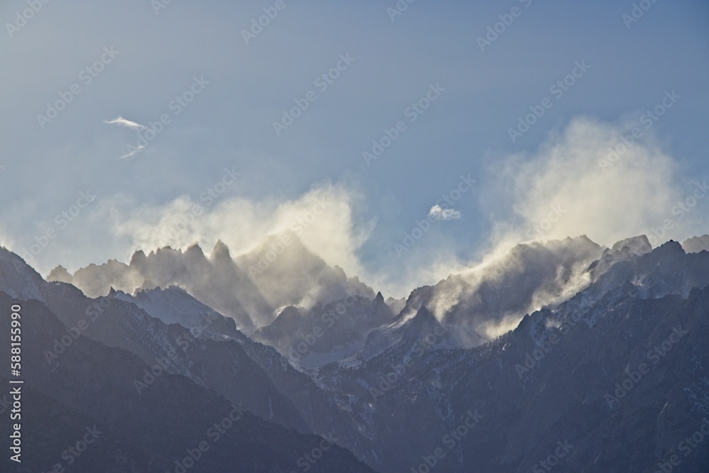 Clouds drift over the Sierra Nevada Mountains, which were dusted in snow, as seen from the Eastern Sierra
