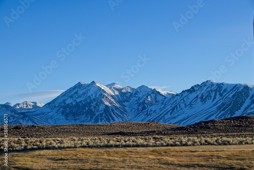 The towering Sierra Nevada Mountains cast shadows on the Eastern Sierra region of California as the sun sinks lower in the sky to set over the mountain range to the West