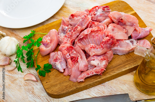 Raw rabbit meat with spices and herbs on wooden cutting board