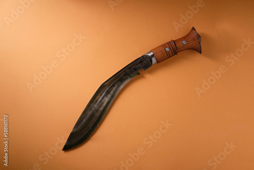 Ancient kukri knife on an orange background, top view photo