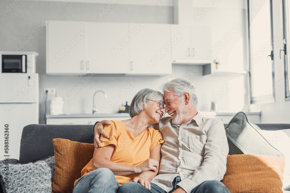 © Daniel - Happy laughing older married couple talking, laughing, standing in home interior together, hugging with love, enjoying close relationships, trust, support, care, feeling joy, tenderness. © Daniel - Happy laughing older married couple talking, laughing, standing in home interior together, hugging with love, enjoying close relationships, trust, support, care, feeling joy, tenderness.