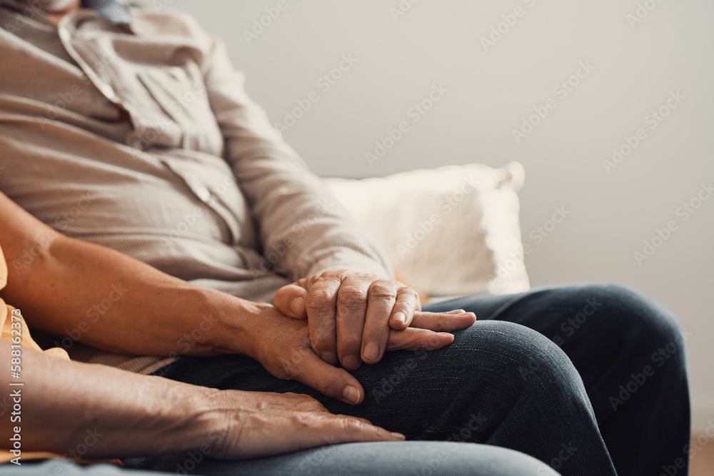 Close up elderly affectionate woman covering wrinkled hands of mature husband, showing love and support at home. Caring middle aged family couple enjoying sincere trustful honest conversation..