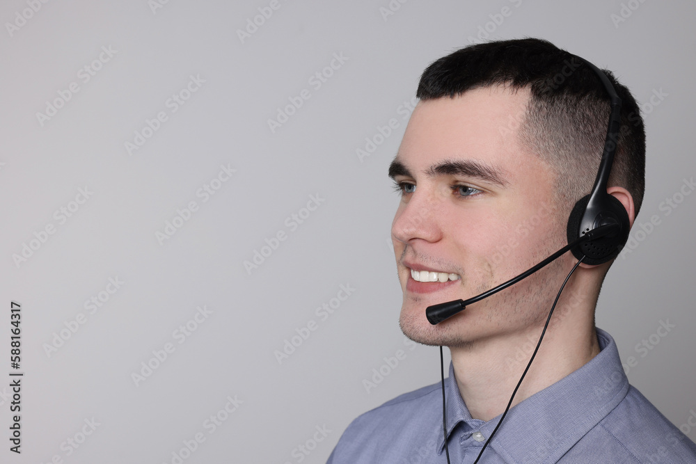 Hotline operator with headset on light grey background, space for text Hotline operator with headset on light grey background, space for text