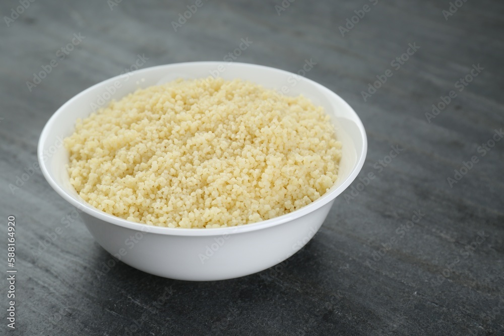 Bowl of tasty couscous on grey table, closeup Bowl of tasty couscous on grey table, closeup