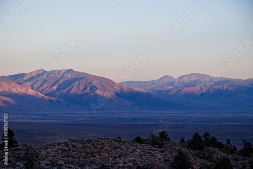 The sun sets over the Sierra Nevada Mountains, casting shadows on Owens Valley in California's Eastern Sierra Region photo