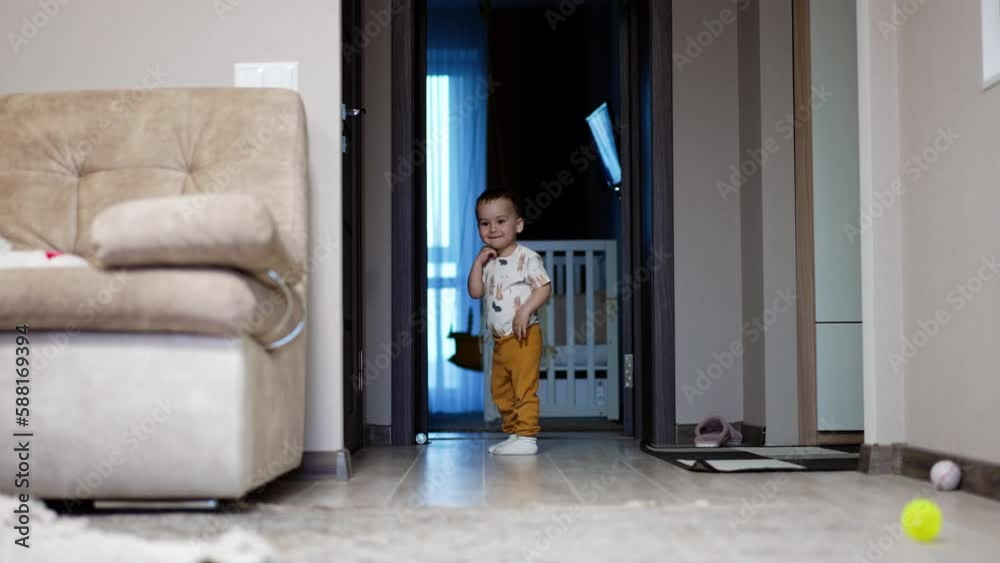 Charming baby boy standing at the doors. Lovely little kid rushes into the room smiling. Charming baby boy standing at the doors. Lovely little kid rushes into the room smiling.