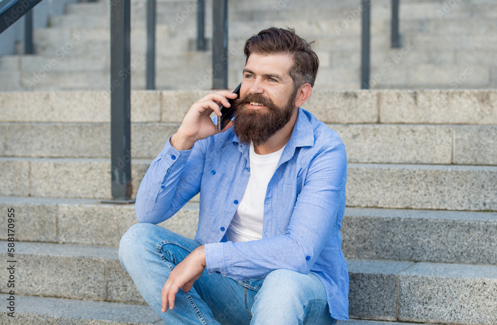 photo of positive man has smartphone call. man has smartphone call outdoor.