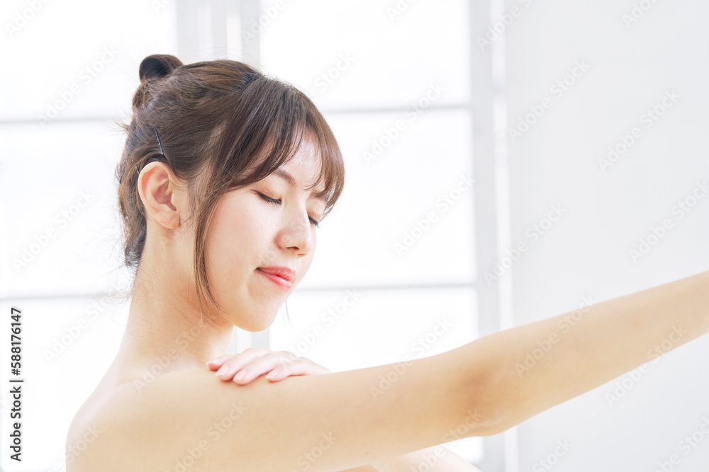 腕のスキンケアをする若い女性 腕のスキンケアをする若い女性