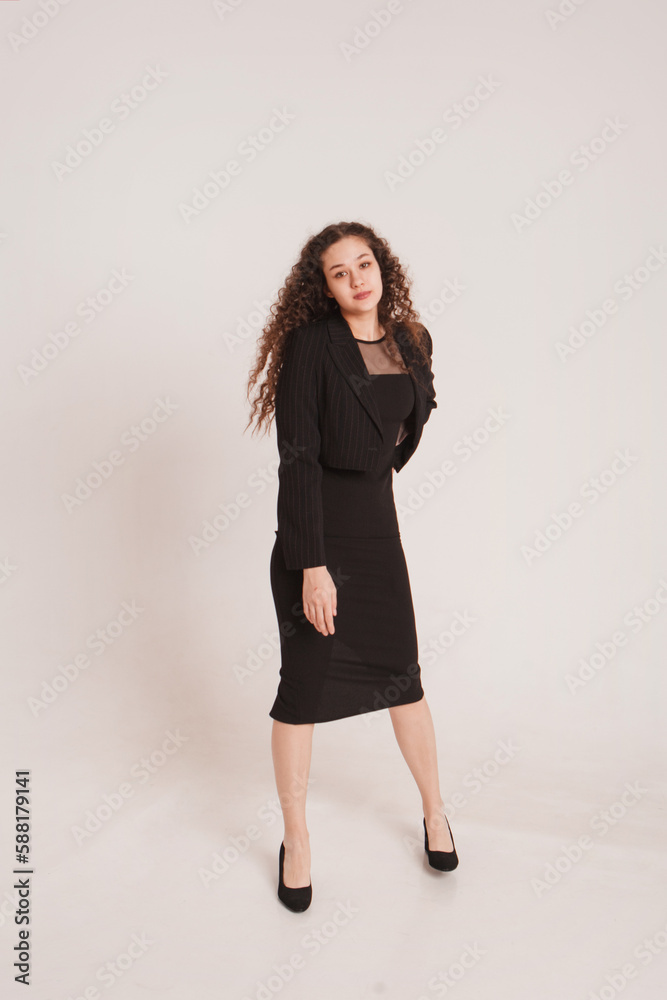 fashion female portrait. Girl, curly girl with black hair in a strict business suit on a white background. High quality photo fashion female portrait. Girl, curly girl with black hair in a strict business suit on a white background. High quality photo