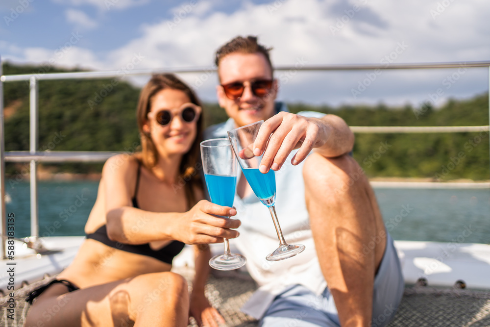 Caucasian young couple drinking champagne while having party in yacht. 