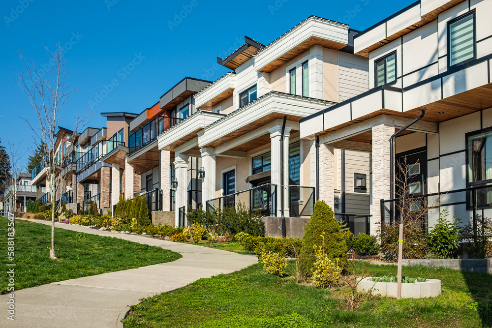 Obraz premium A perfect neighborhood. Houses in suburb at Spring in the north America. Real Estate Exterior Front House on a sunny day