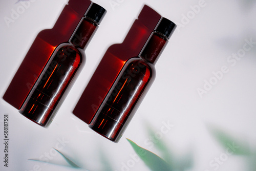 Cosmetic bottles made of dark amber glass on a white background.