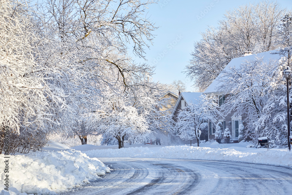 Naklejka premium Icy and snowy road curving through the neighborhood after a surprising snowstorm in April near Minneapolis Minnesota