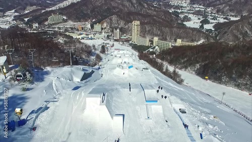 Aerial drone forward moving shot over ski tracks in Pyeongchang Phoenix Snow Park ski resort town in Gangwon-do, South Korea at daytime.