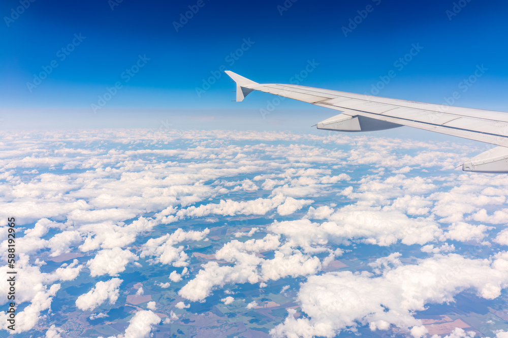 Fototapeta premium View from the airplane window at a beautiful cloudy sky and the airplane wing
