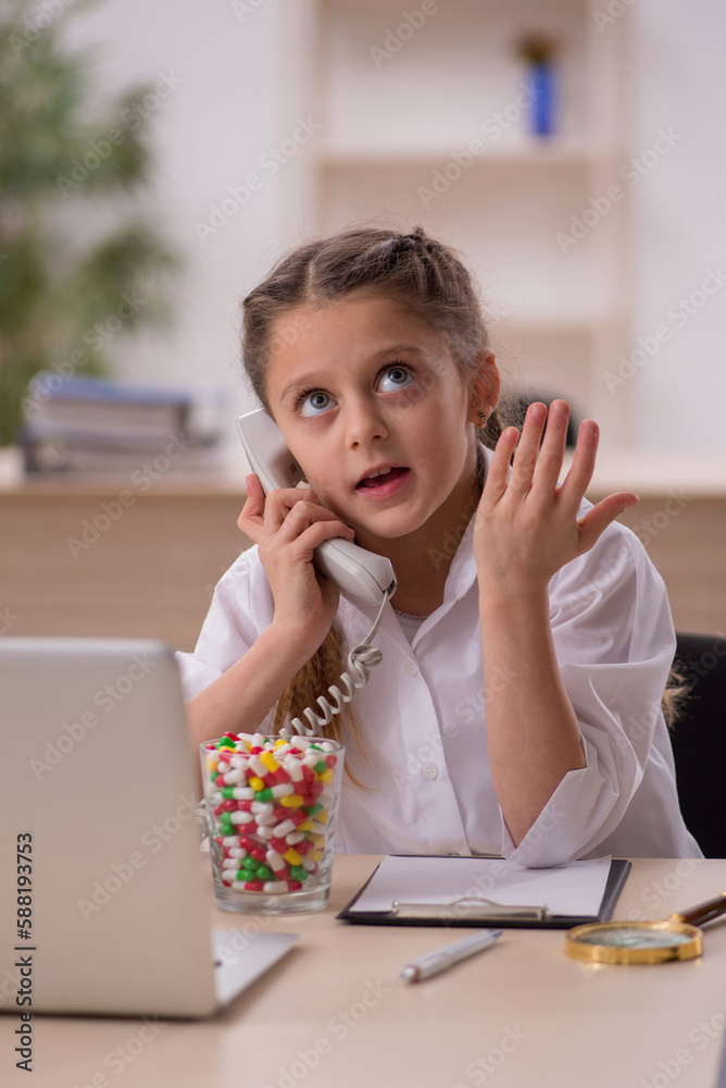 Small girl playing doctor in telemedicine concept Small girl playing doctor in telemedicine concept