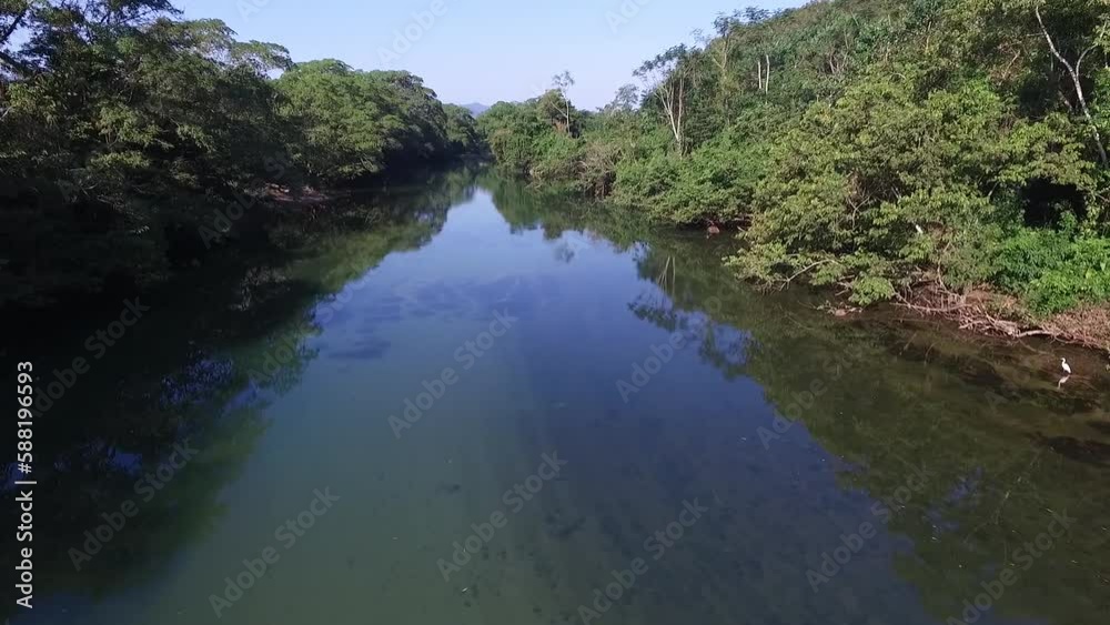 Low altitude flight over the transparent water of the uxpanapa river surrounded by tropical vegetation. Veracruz, Uxpanapa, Mexico. Low altitude flight over the transparent water of the uxpanapa river surrounded by tropical vegetation. Veracruz, Uxpanapa, Mexico.