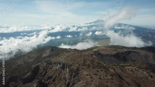 Flight from the summit of Cofre de Perote National Park towards Pico de Orizaba, Citlaltepetl, with fog rising from the forest. photo