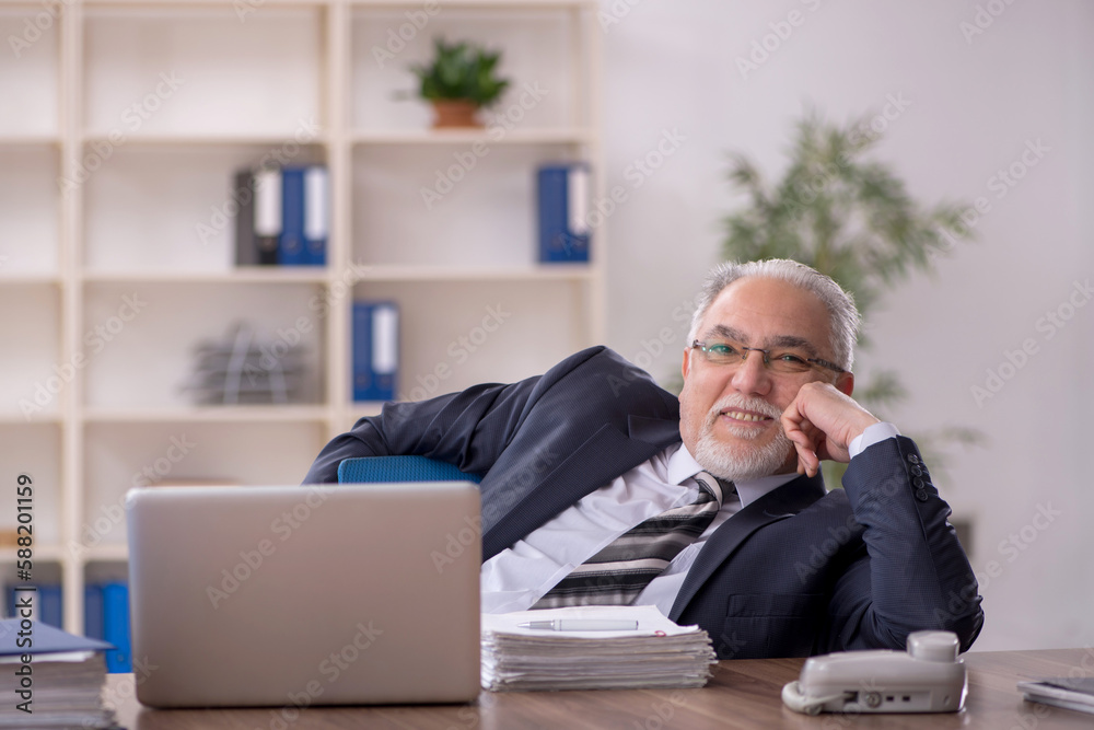 Old male employee working in the office Old male employee working in the office