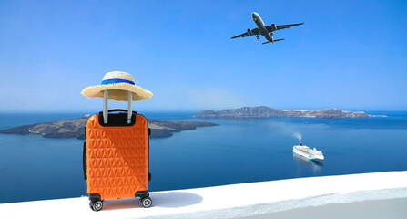 Banner of travel concept with Orange luggage and hat as landscape view of Oia town in Santorini island in Greece , Greek landscape as blue sky background