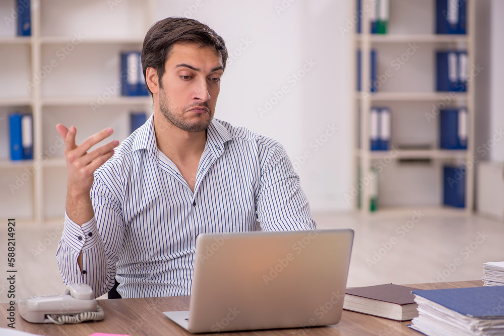 Young male employee working in the office Young male employee working in the office