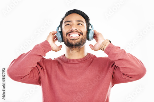Headphones, smile and music, happy man in studio isolated on white background streaming radio and happiness. Podcast subscription, technology and song, Indian guy listening to audio online to relax.