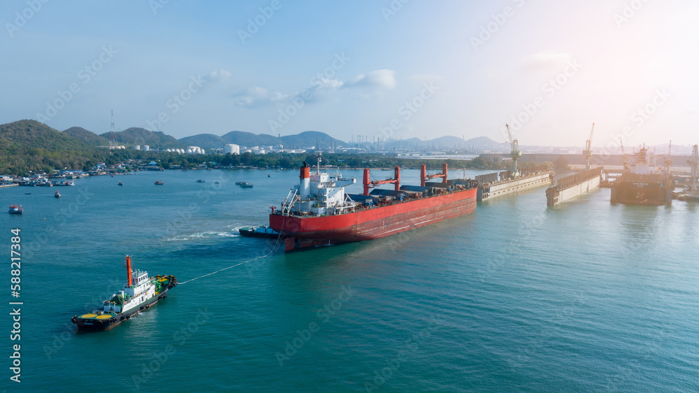 Tug boat Draging cargo container ship to dry dock concept maintenance service working in the sea. Insurance and Maintenance Cargo Ship concept. Freight Service maintenance Insurance