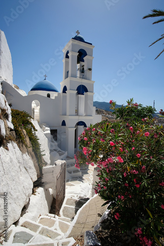 View of the beautiful whitewashed Orthodox Church of Panagia Gremniotissa, surrounded by beautiful flowers