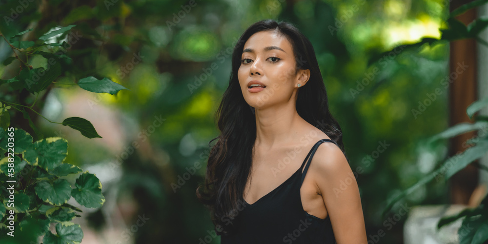 Beautiful girl in the garden on a sunny day, sexy Asian woman wearing black dress and posing to take a portraits photo, Art fashion spring model girl in day home forest, nature outdoor scene Beautiful girl in the garden on a sunny day, sexy Asian woman wearing black dress and posing to take a portraits photo, Art fashion spring model girl in day home forest, nature outdoor scene