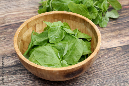 fresh spinach in a wooden bowl