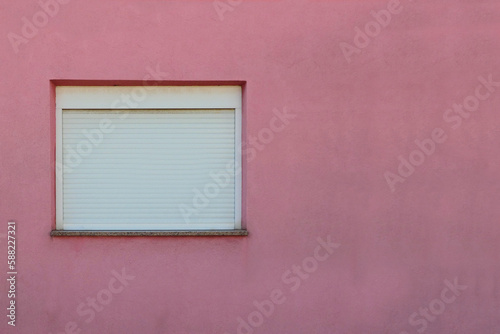 white window with shutters on pink wall © Angela