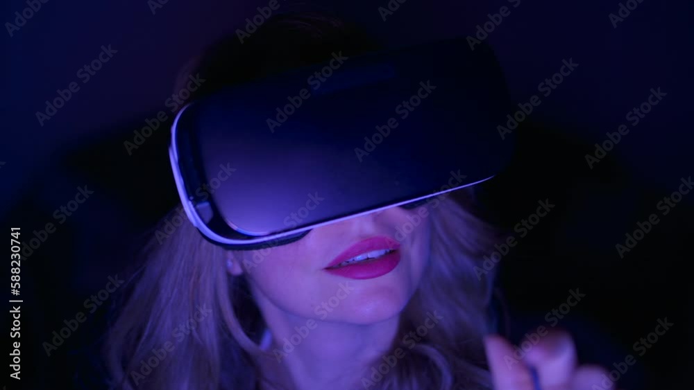Woman in VR helmet playing at home Woman in VR helmet playing at home
