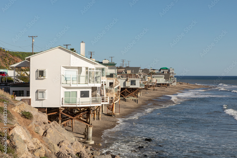 beautiful houses at wooden support poles at the scenic beach in Malibu, California, USA.