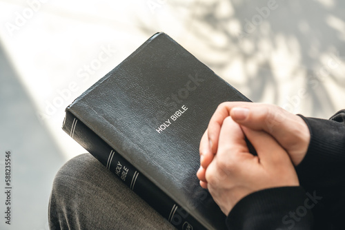 Close-up, holy Bible book in male hands.