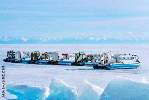 Hovercrafts on Lake Baikal. Airboat, winter transport extreme. Hovercraft sliding fast on the surface of the transparent frozen Lake. Baikal ice.