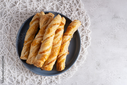 Appetizing cheese sticks on a blue plate on a light background