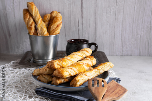 Cheese sticks made of puff pastry on a blue plate. Delicious snack, breakfast