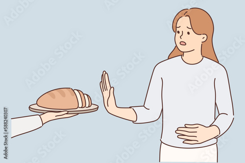 Frustrated woman holding on to stomach refuses bread due to allergies and gluten intolerance