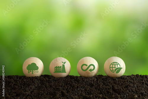 Growing sustainability. LCA-Life cycle assessment concept. Environment icons on wooden sphere balls on a green background. Concept of environmental impact assessment related to product value chains.
