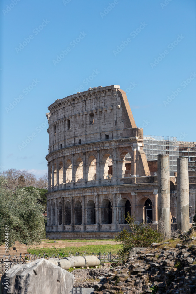 Glimpse of ancient Colosseum in Rome on a sunny day. Roman amphitheater and sun in Italy