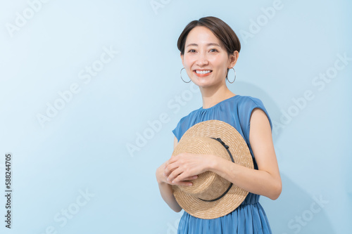 帽子を持ちワンピースを着た日本人女性